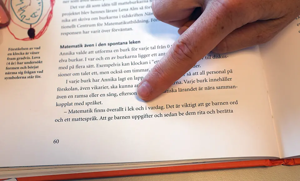 Ett finger pekar på ett citat från boken "Alla talar om matte redan i förskolan".