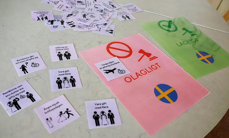 Korten med bilder och texter om olika äktenskaps- och relationsregler samt en grön lapp med ordet ”Lagligt” och en röd med ”Olagligt”, 