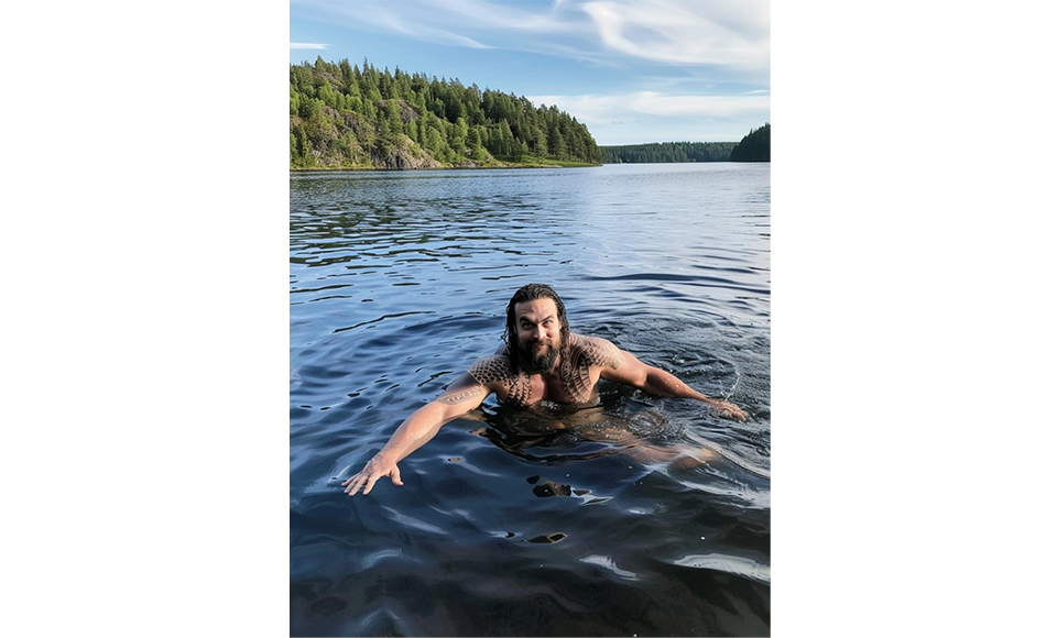 En AI-genererad bild på Jason Momoa som simmar naken i en svensk sjö.