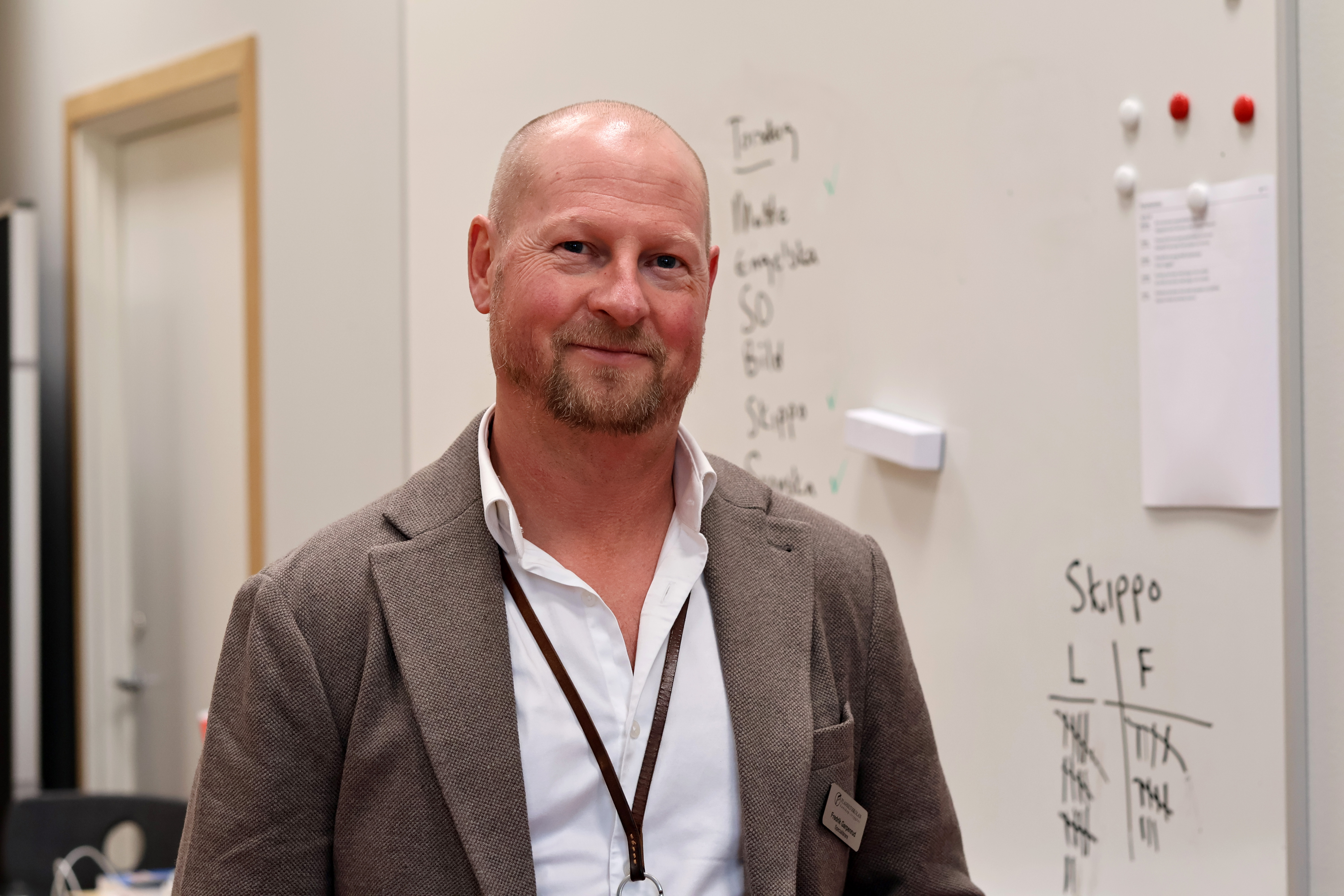 Fredrik Garpenrud framför en whiteboardtavla där dagens planering står skrivet.