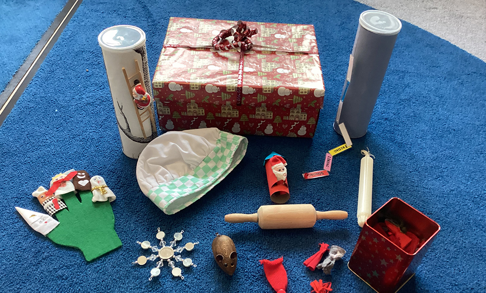 På en blå matta står saker som förknippas med jul och lucia. Bland annat en kavel, en julklapp, ett ljus och små fingerdockor.