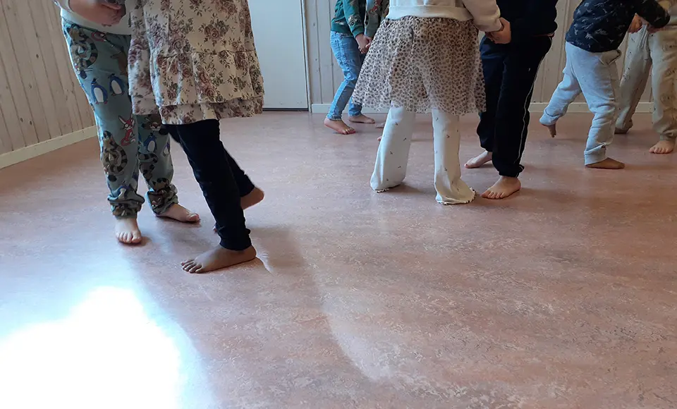 Bilden visar ben på flera barn som ser ut att dansa två och två.