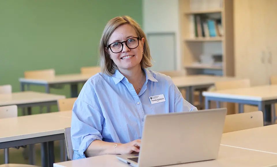 Pernilla Emilsson som sitter i en bänk med dator framför sig.