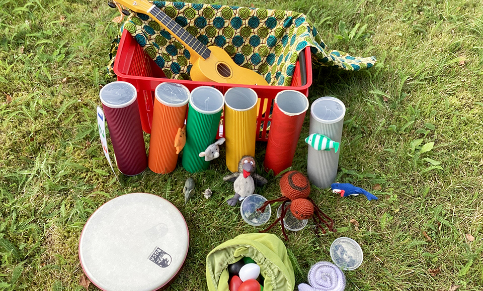 På bilden finns sångrör, en ukulele, äggmaracas, gosedjur och andra instrument.